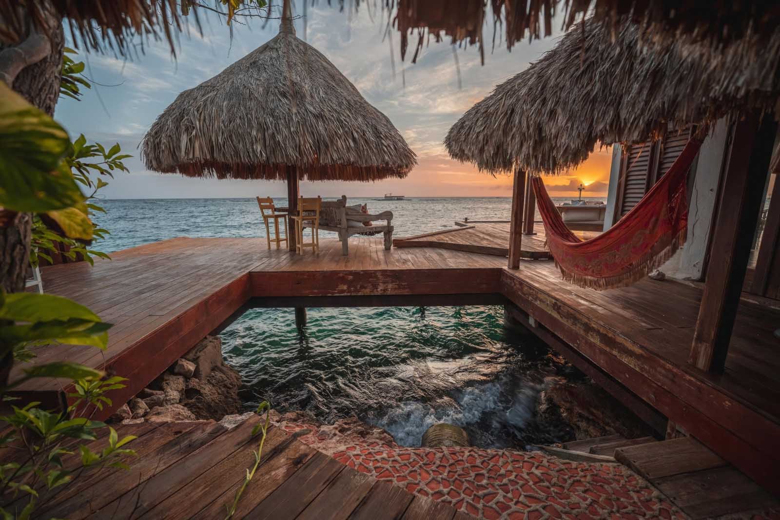 Overwater bungalow at Aruba Ocean Villas with hammock and plunge pool above turquoise Caribbean waters