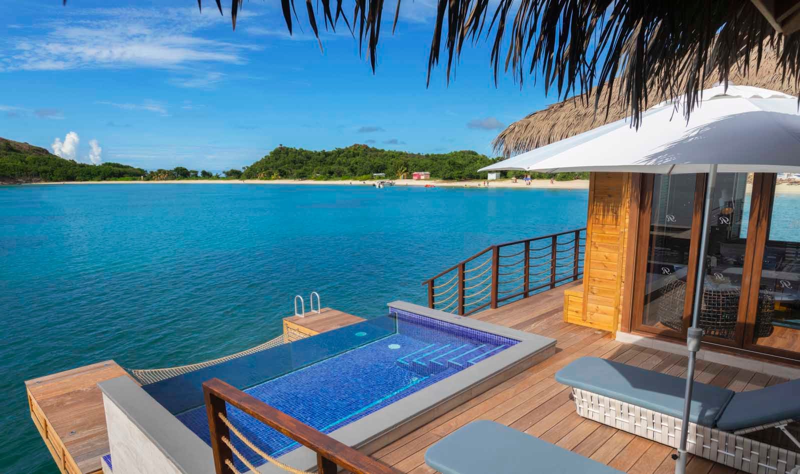Chairman’s Overwater Bungalow at Royalton Antigua with king-size bed, infinity pool, and oceanfront deck