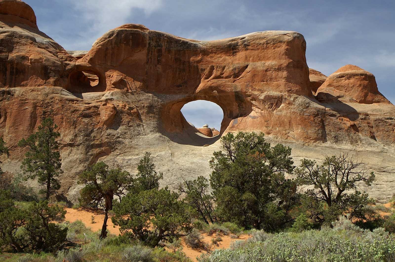 Devils Garden Primitive Loop trail with hikers walking past Landscape Arch in Moab, Utah


