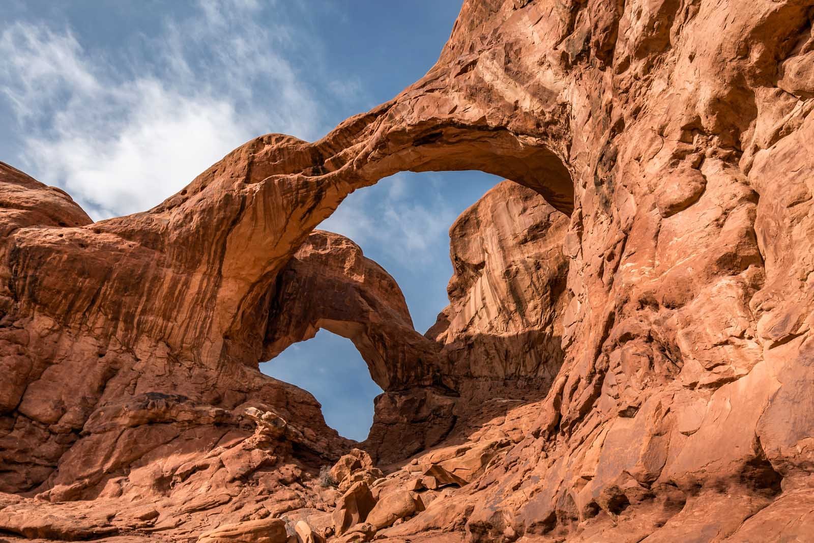 Double Arch in Arches National Park with two massive arches above red desert floor

