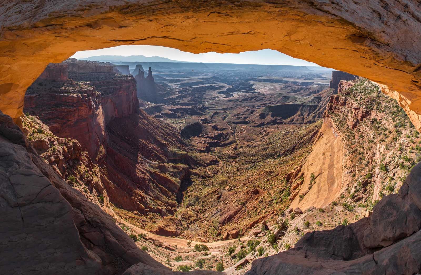 Mesa Arch sunrise view in Canyonlands National Park with light shining through arch

