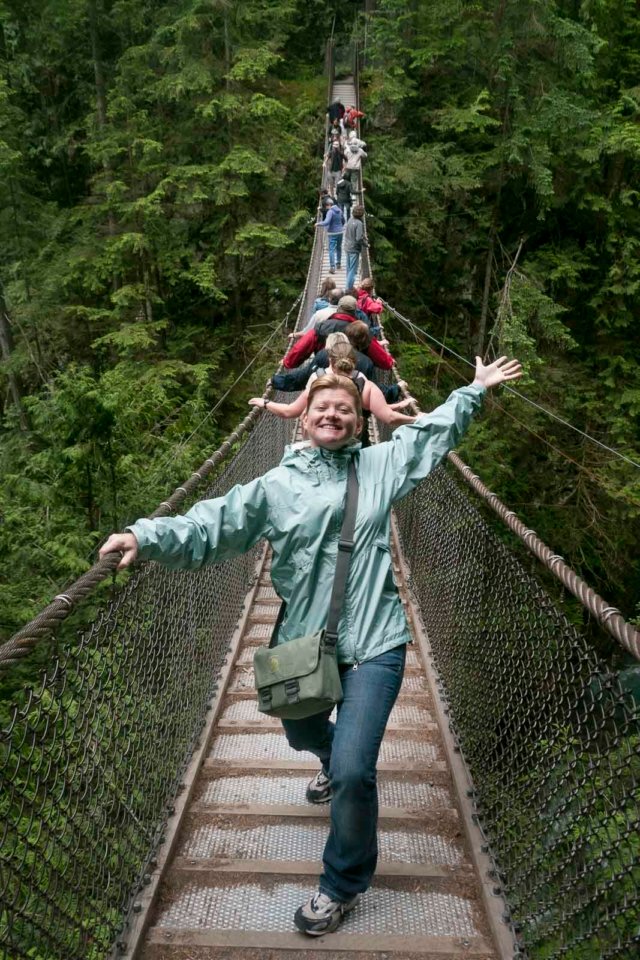 A woman is standing on the Capilano suspension Bridge