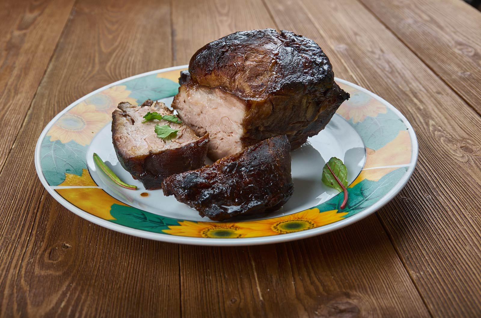 A cross-section of a roasted Pernil Relleno, revealing a pork shoulder stuffed with Moros y Cristianos (black beans and rice)