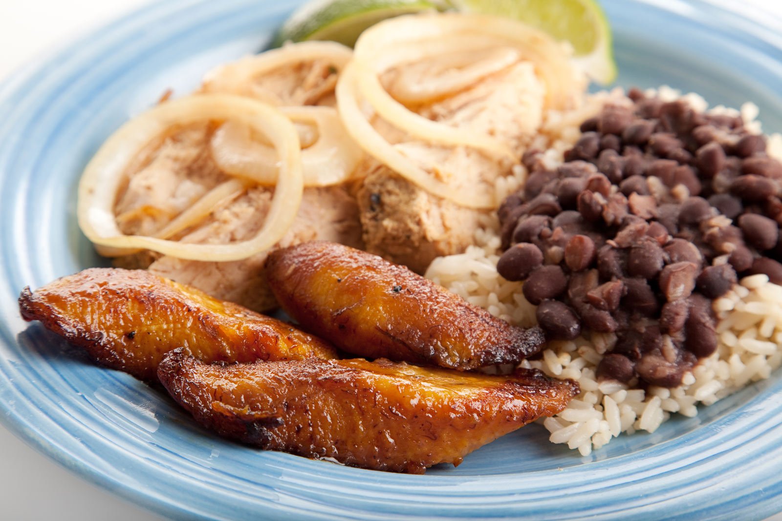 A side dish of Plátano Maduro Frito, showing caramelized, golden-brown sweet fried plantains.