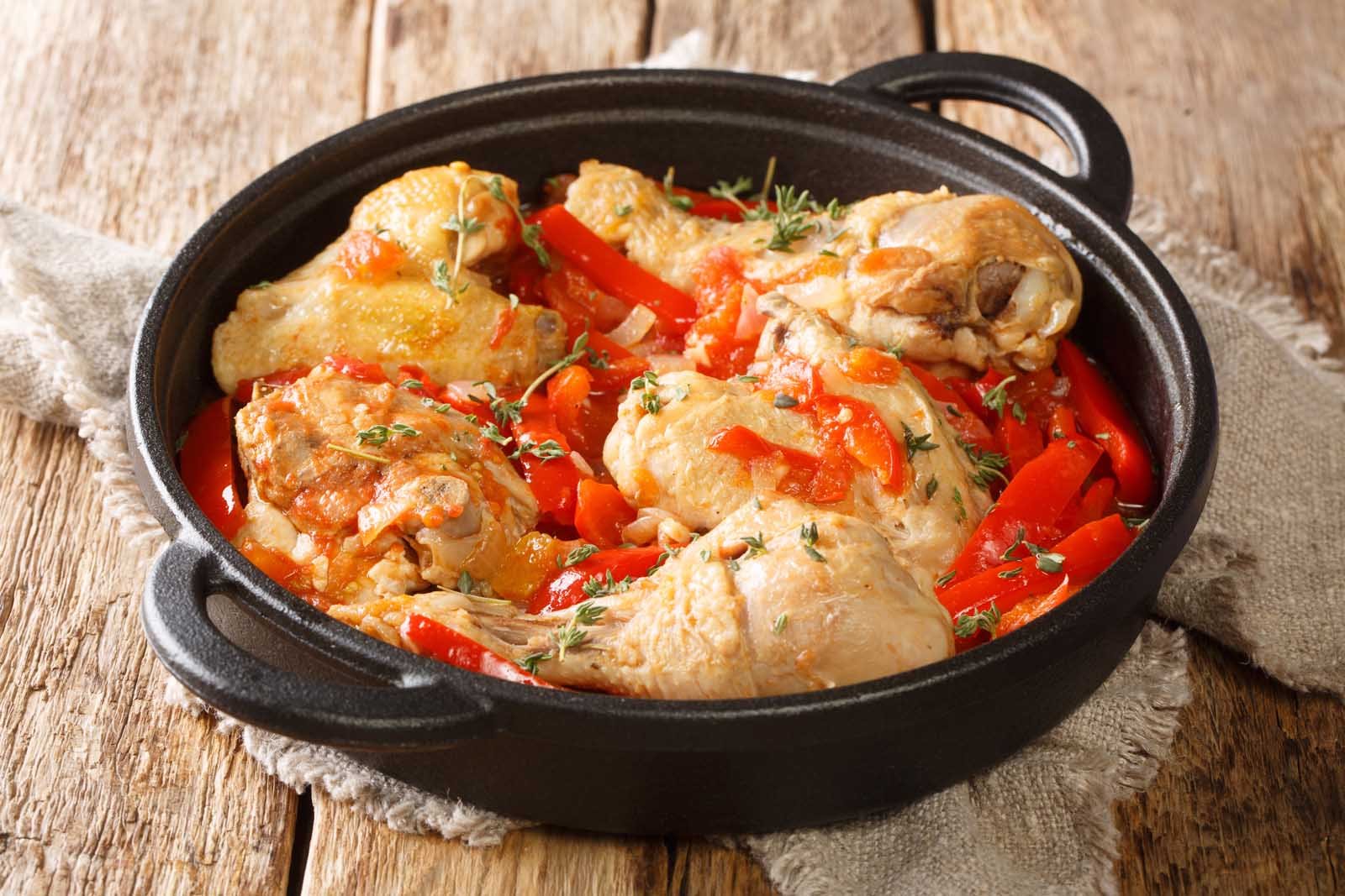 A vibrant dish of Poulet Basquaise, a French chicken stew with sweet peppers and Espelette chili.