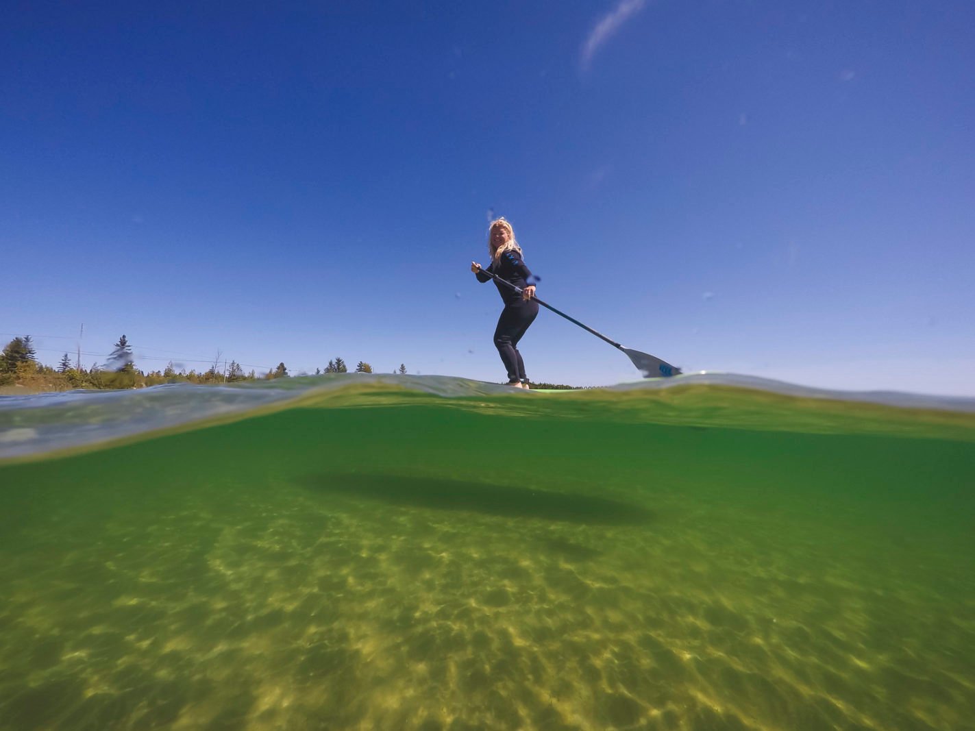 De Stand Up Paddle Boarding on Lake Superior wearing a wet suit