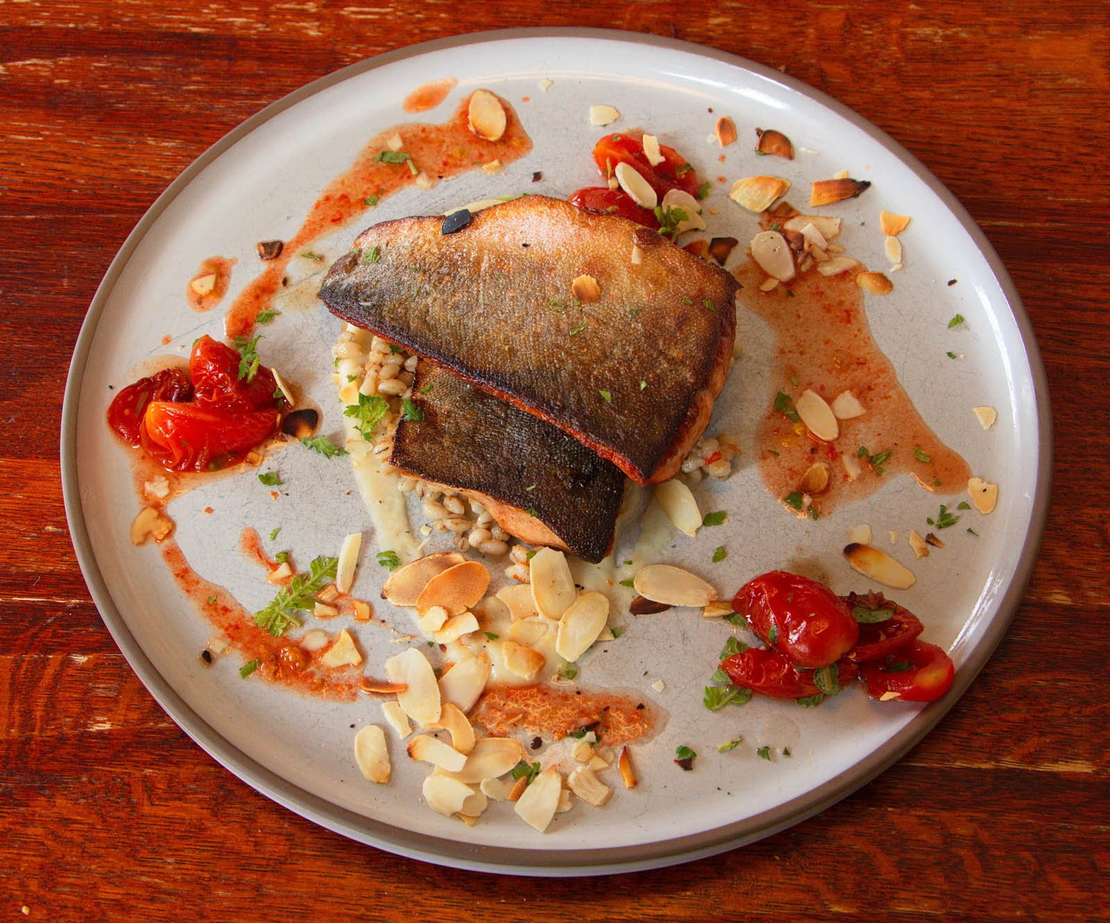 Grilled Arctic char fillet with tomatoes and almonds served in Seyðisfjörður, Iceland.
