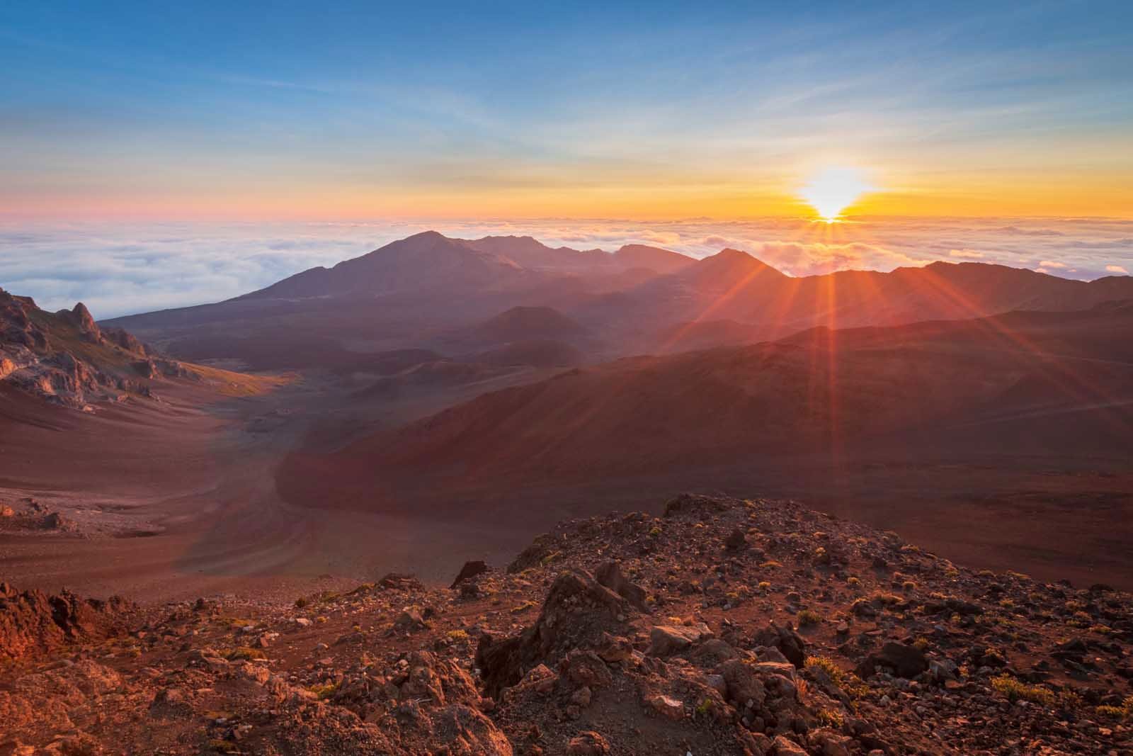 watching the sunrise from above a sea of clouds at the summit of Haleakal? National Park in Maui.