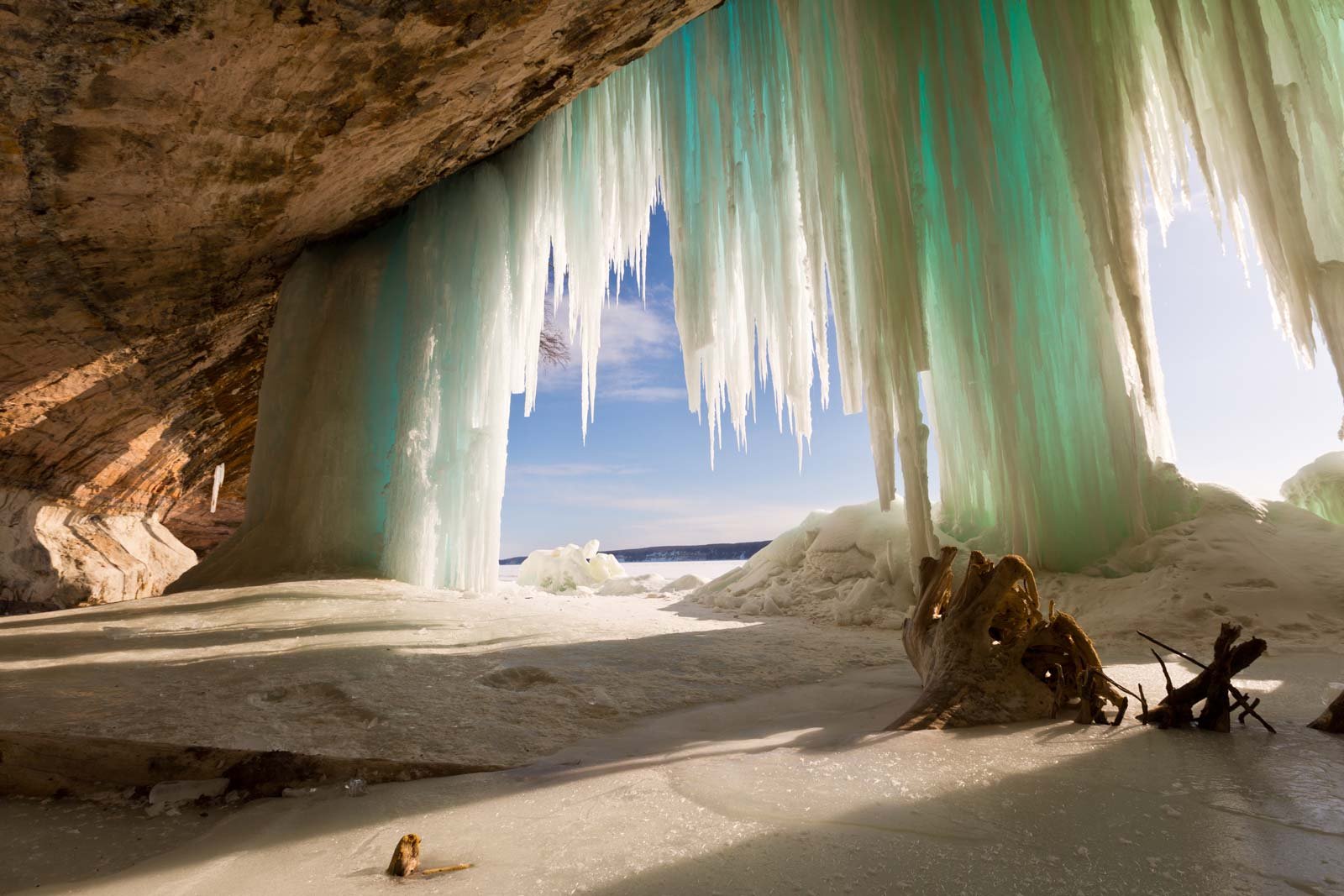 Stunning blue ice caves and giant icicles formed along the sandstone cliffs of Grand Island in winter, a magical Upper Peninsula experience.
