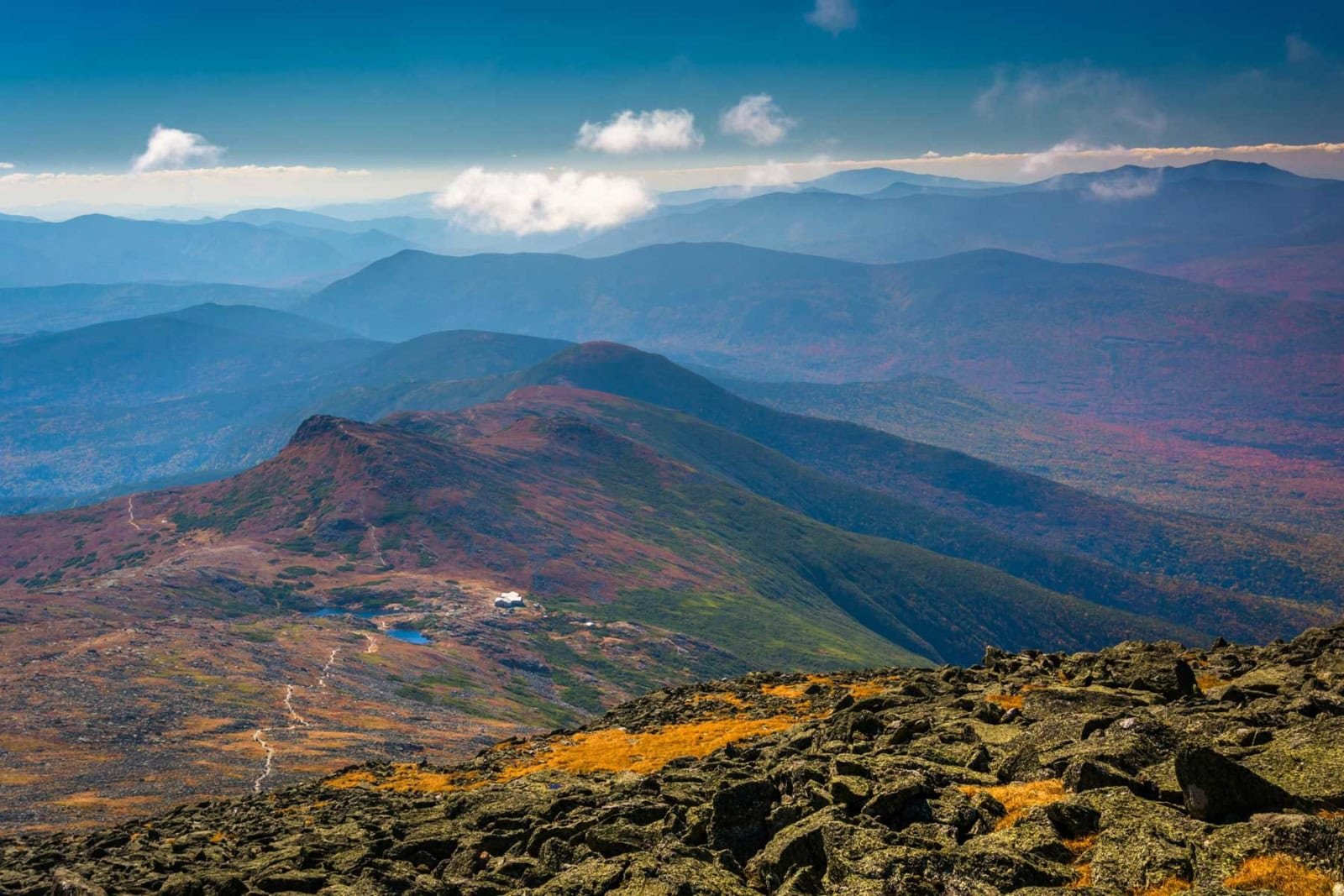 Aerial view of Kancamagus Highway winding through peak fall colors in the White Mountains