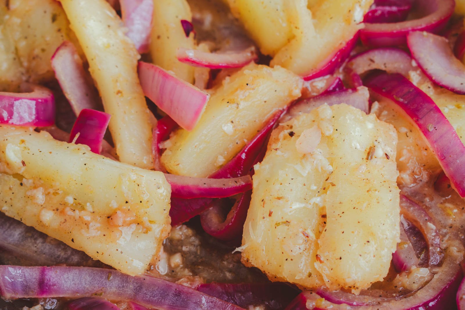 oiled yuca topped with a generous amount of shiny mojo de ajo, a Cuban garlic and citrus sauce.