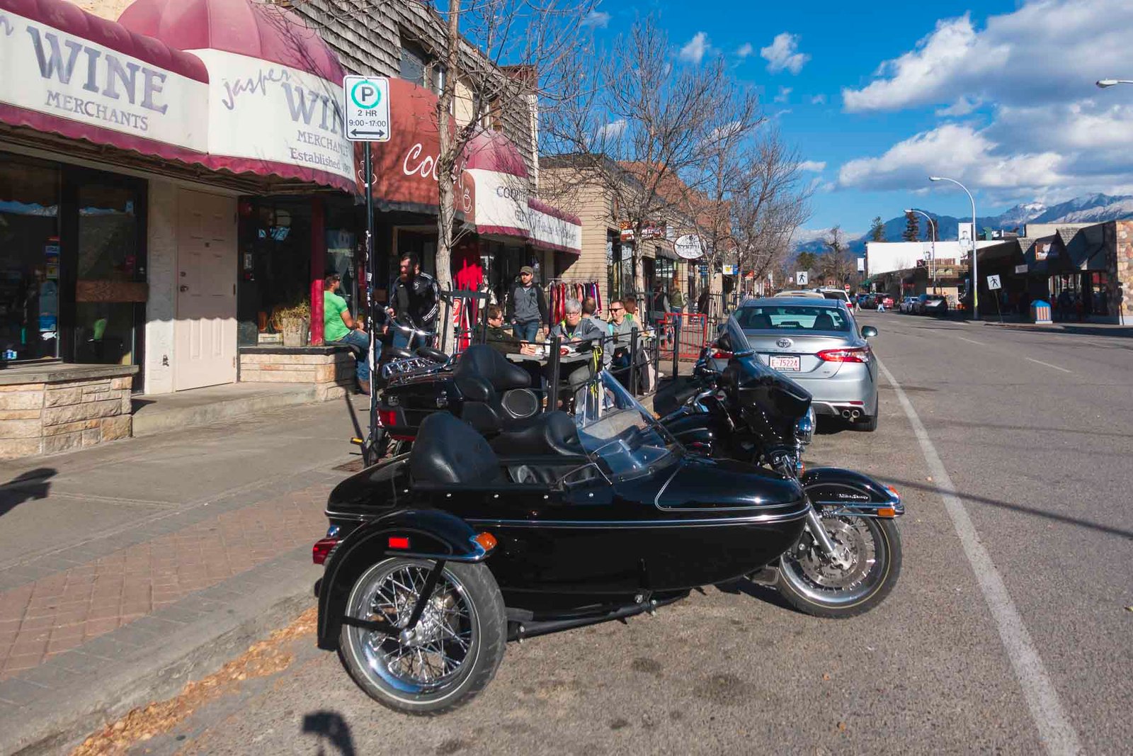 The charming main street of Jasper town, with shops, restaurants, and mountains visible in the distance.