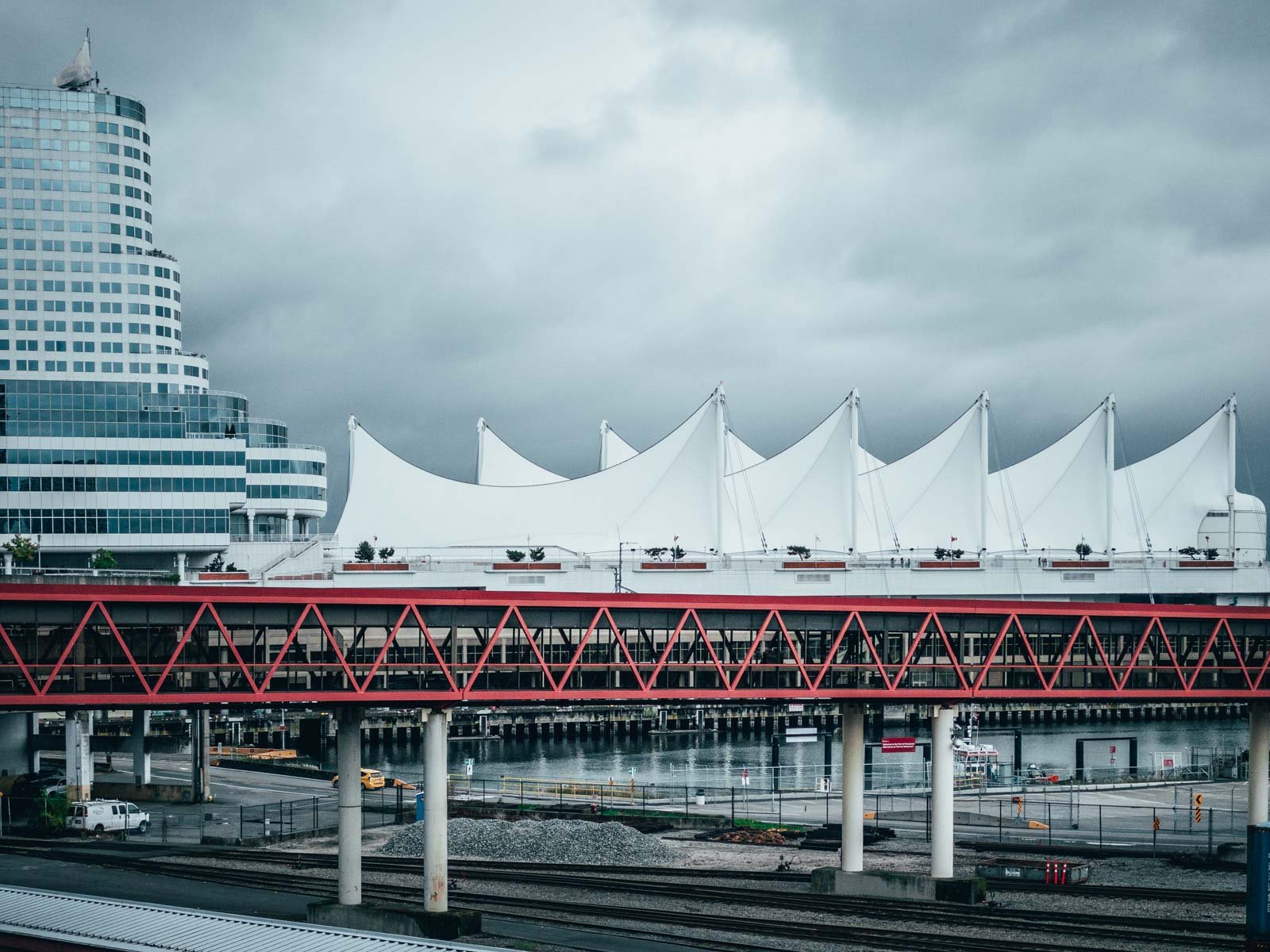 The iconic white sails of Canada Place on the waterfront in downtown Vancouver, with mountains in the background.