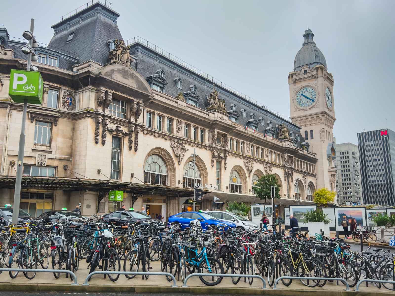 The busy front entrance of Gare de Lyon train station in Paris, showing a transit-focused area that lacks the classic Parisian charm.