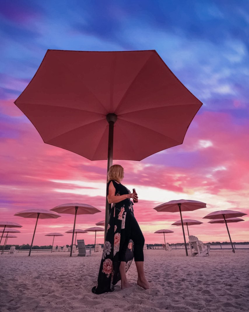 Deb from The Planet D under the iconic pink umbrellas on the sand at Sugar Beach, on Toronto's revitalized waterfront.
