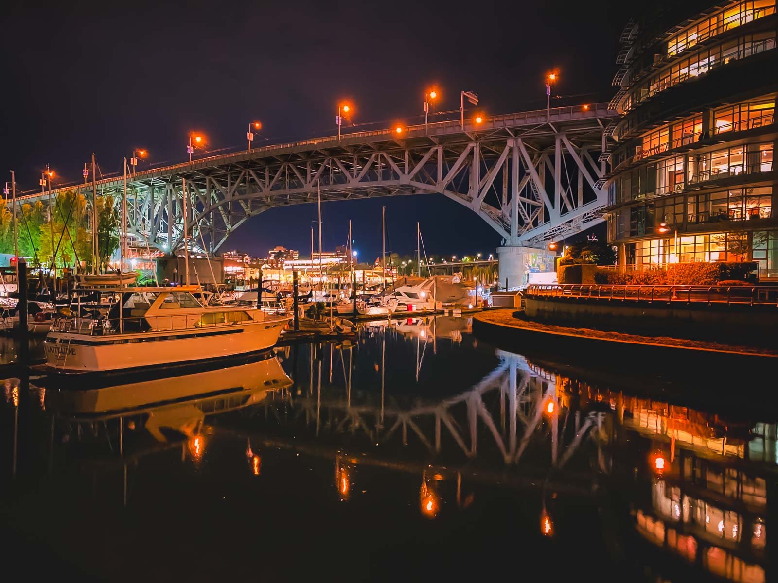enjoying a walk along the Yaletown section of the Seawall, with False Creek and the city in the background at night.
