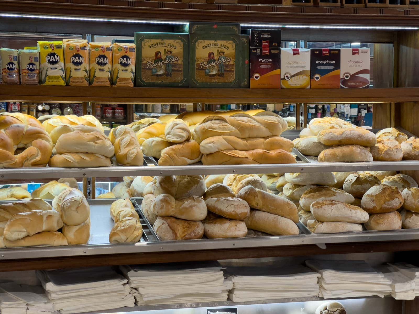 Pão de Deus, a sweet Portuguese bread roll with a toasted coconut topping on the shelves at a Portuguese bakery in Lisbon